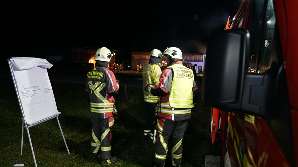 Donnerstag der 31 Oktober 18.30 Uhr. Die Sirenen heulen im Ammertal von Saulgrub bis Graswang. Einsatzort ist ein Bauernhof zwischen Unterammergau und Scherenau. Es handelt sich Gott sei dank nur im eine größer angelegte Übung der Feuerwehr Unterammergau. Es wurde ein Brand im Heustock mit eingeschlossenen Personen angenommen. Das Problem bei diesem Übungsobjekt; ist die nicht vorhandene Wasserversorgung. So wurde um die Wasserversorgung zu gewährleisten, welches im Ernstfall für den Innenangriff sowie für die Abschirmung der umliegenden Gebäude benötigt würde insgesamt 5 B-Leitungen (3 von der Ammer/2 vom Hydrantennetz) gelegt. Die Einsatzkräfte haben insgesamt über 3 km Schlauchleitungen zum Einsatzort verlegt. In der Übergangszeit bis die Leitungen fertig verlegt waren wurde ein Pendelverkehr eingerichtet. Wir möchten uns rechtherzlich bei den Organisatoren sowie bei den über 100 Einsatzkräften bedanken welche bei unserer Übung teilgenommen haben. Außerdem ein recht herzliches Vergelts Gott bei der Familie Buchwieser für das bereitstellen des Übungsobjektes.